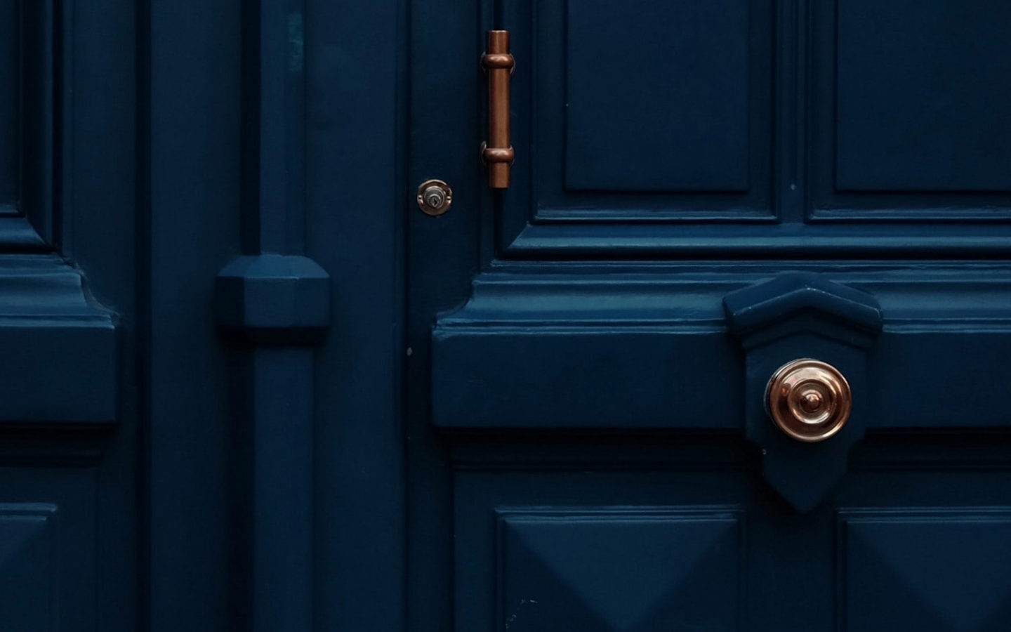 deep blue wooden door with copper accents