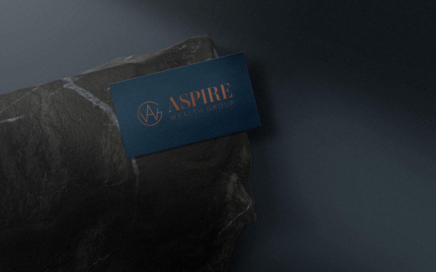 aspire wealth business card sitting on top of stone