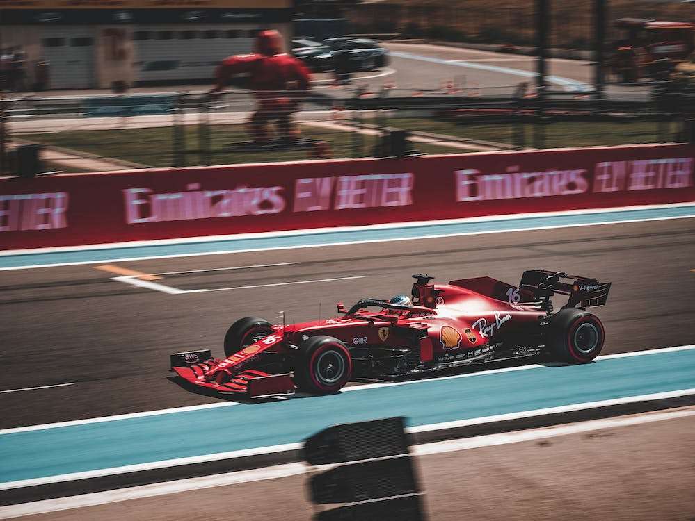 a red race car driving down a race track