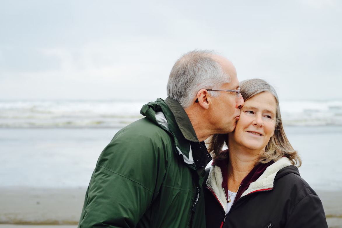 a man and a woman kissing on the beach